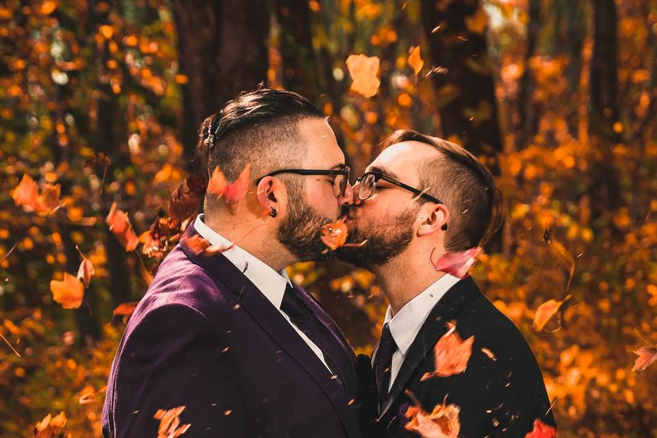 Couple kiss among autumn leaves