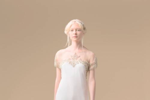 Ana is a brushed silk charmeuse column gown. The sloped-shoulder illusion neckline is covered in intricate beading.