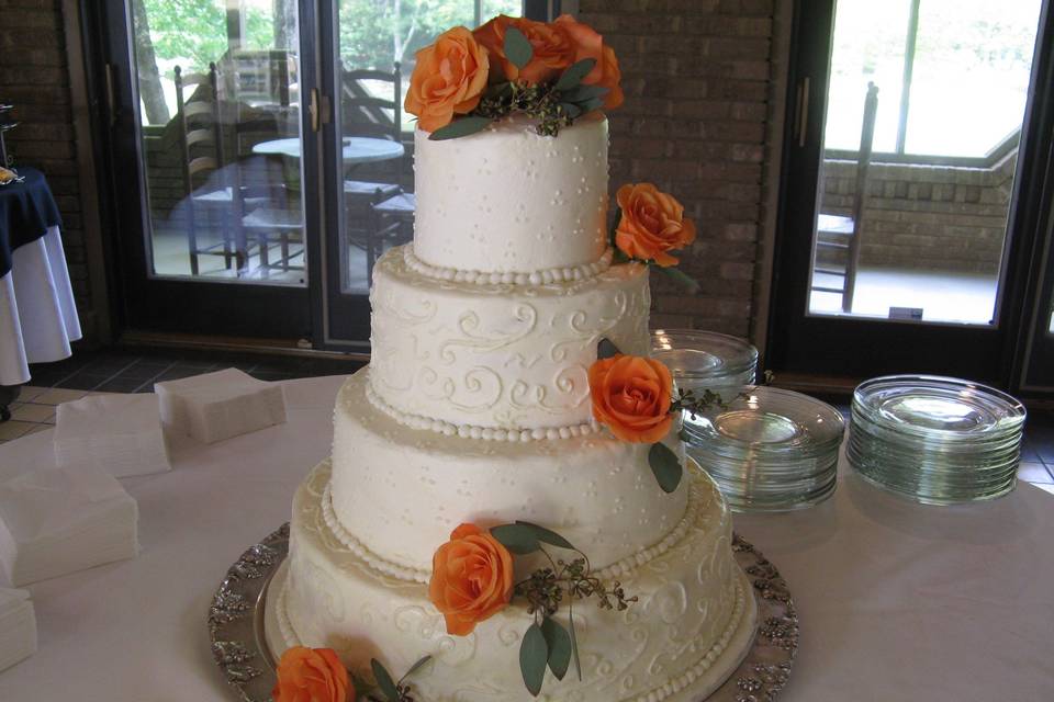 cake with coral colored roses