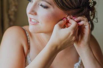 Bride putting on her earrings