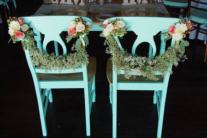 Sweetheart table decorated with garlands of baby's breath and small bouquets of ivory and coral garden roses. Wedding flowers at Paradise Ridge. Floral Design by The Wild Orchid. #wildorchid707 #floraldesign #winecountrywedding #weddingflowers #weddinginspiration #chairflowers #weddingdecor #garlands #babysbreath #gardenrose #vintage