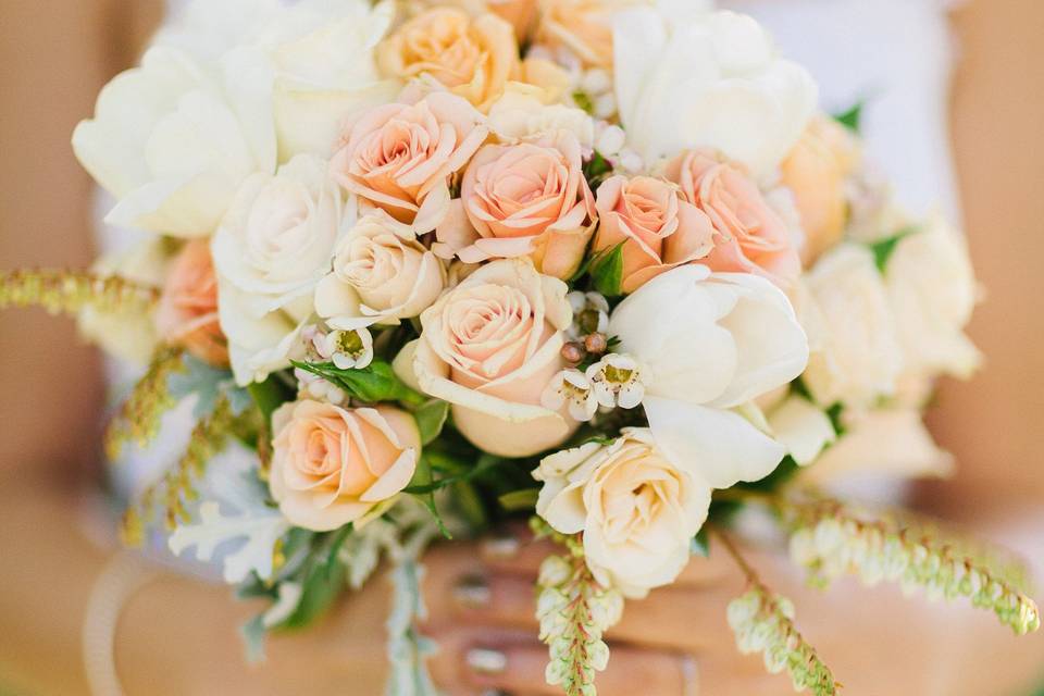 Peach and creams hand tied bridal bouquet for summer wedding at Vine Hill House in Sebastopol. Using roses, spray roses, tulips and dusty miller the bouquet was wrapped with an ivory ribbon and studded with pearl headed pins.Sonoma County wedding. #wildorchid707 #sonomaweddings #sonomaflorist #weddingflowers #floraldesign #weddings