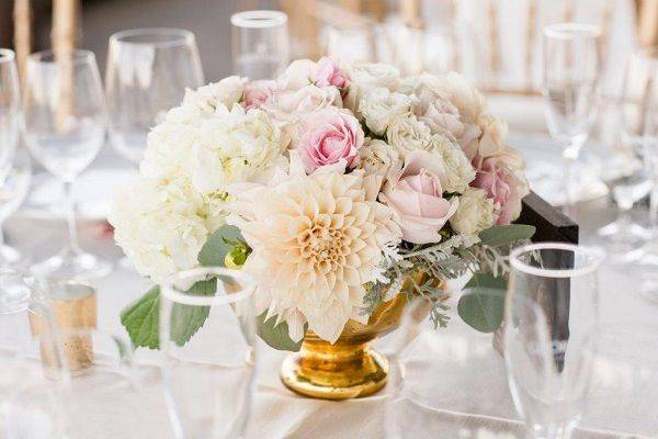 Gold mercury vases filled with dahlias, garden roses, spray roses, hydrangea, dusty miller & eucalyptus! Love the blend of blush, peach & cream together with those green & gold accents.