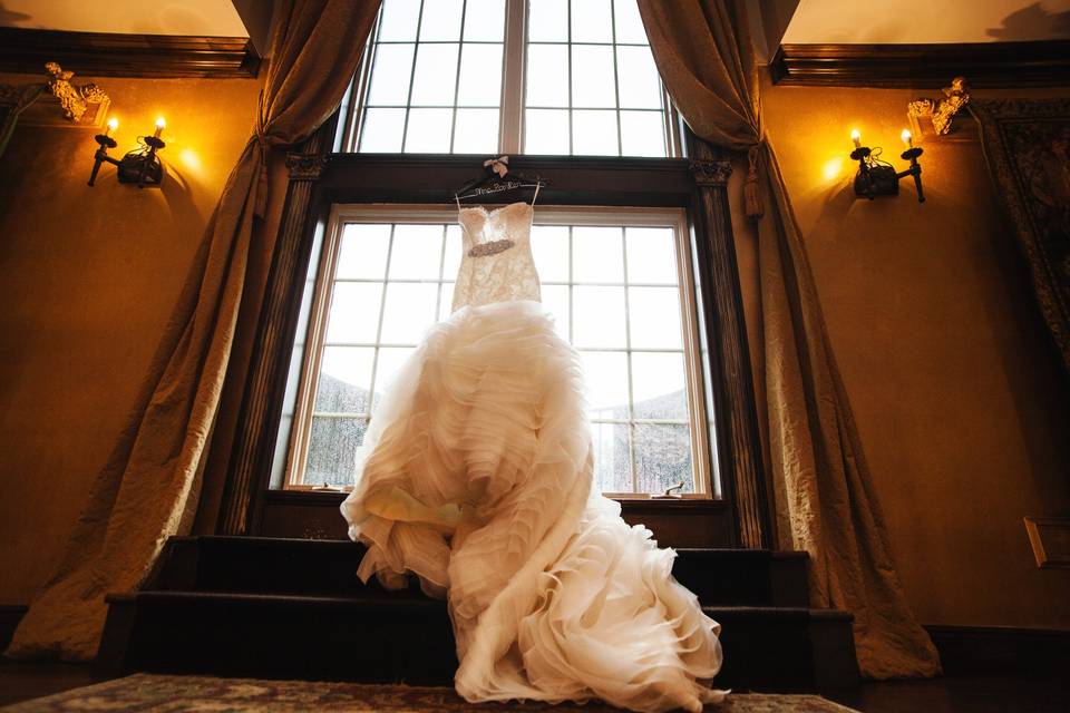 Wedding dress hangs in the window at Barclay Villa