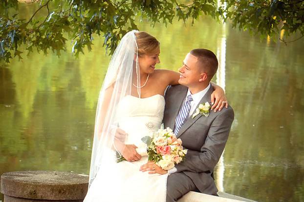 Bride and groom sitting by the pond at the Oaks at Salem wedding venue
