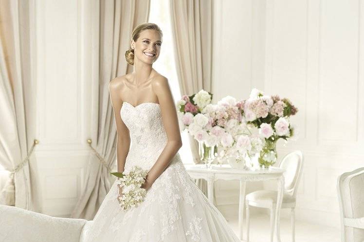 ALCANARThe Alcanar model from the Glamour by Pronovias 2013 collection is made in tulle and delicate lace. This princess wedding dress has a romantic look set off by a wonderful sweetheart neckline. This flattering neckline is delicately defined by the bodice with its rebrodé lace. The elegant skirt on this wedding dress features a marvelous cascade of original appliqués that fall softly to the hem.