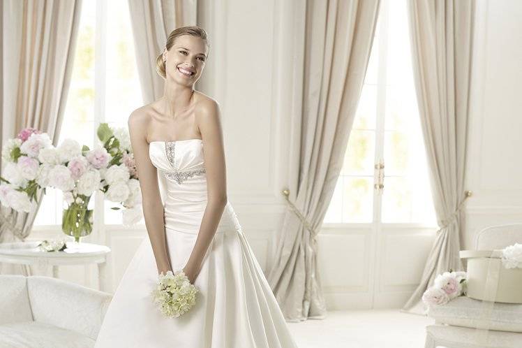 ULEYThe Uley dress from the Glamour by Pronovias 2013 collection is a princess dress made in delicate satin. The dress has a flattering off-the-shoulder neckline with original silver beading. A softly draped bodice complements a skirt with side pleats and a marvelous train.