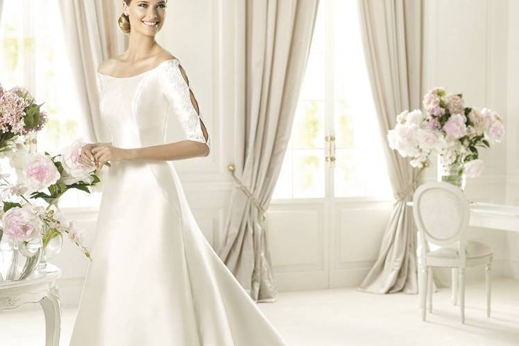 UBALDIThis wedding dress is made of soft mikado silk. Ubaldi, an A-line wedding dress from the Costura by Pronovias 2013 collection, owes its elegance to a beautiful scoop neckline. Elbow-length sleeves, open at the sides, are decorated with original soutage and beading. The elegant skirt embellishes the flattering silhouette and accentuates the delicacy of the model.
