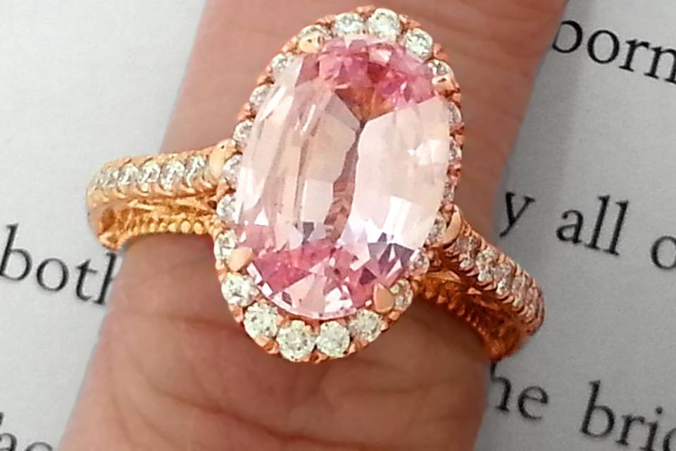 A custom Verragio rose gold engagement ring featuring a light pink oval sapphire.
