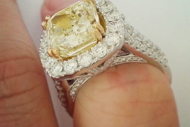 We remounted a customer's large fancy yellow cushion cut diamond into this diamond encrusted halo engagement ring.