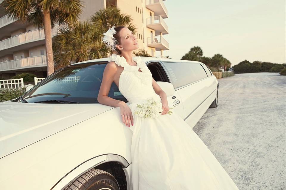 Bride posing with the limo
