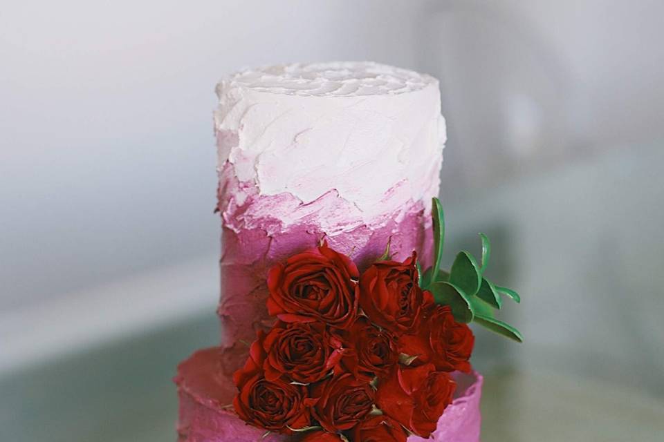 Pink and white cake with red flowers