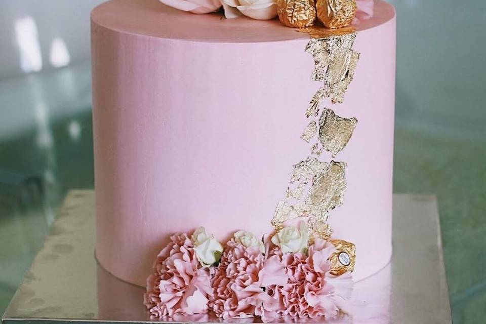 Pink cake with flowers and gold leaf