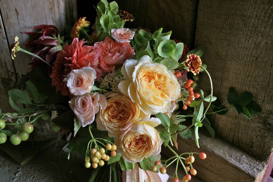 Perfect for an elegant barn wedding.  A bridal bouquet overflowing with English Garden Roses and berries by White Magnolia Designs.