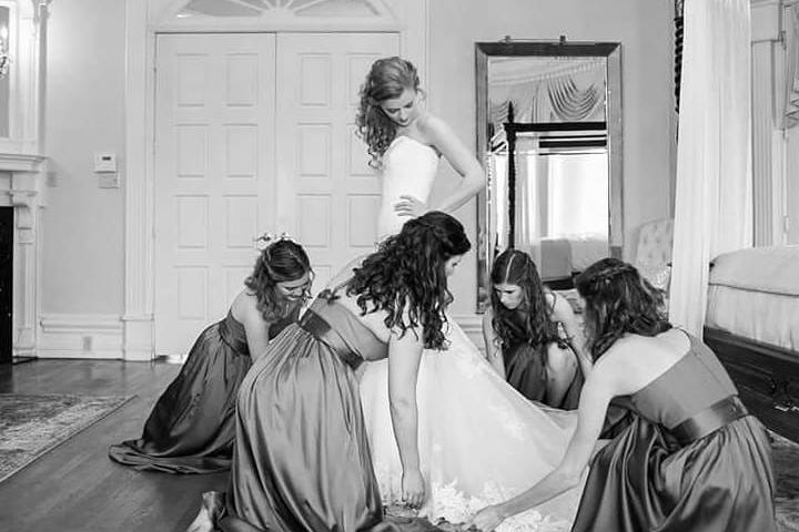 Bridesmaids dressing bride