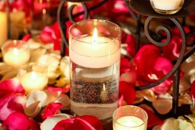 Romantic collection of floating and pillar candles surrounded by lush rose petals.
