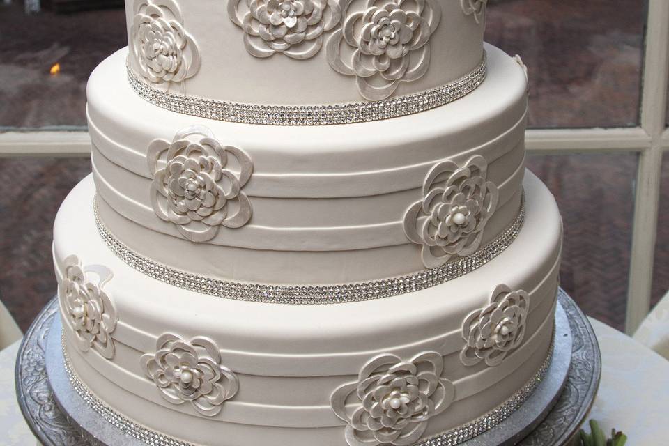 Four layered wedding cake with a flower on top