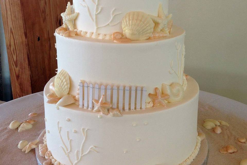 Beach wedding cake with figurines on top