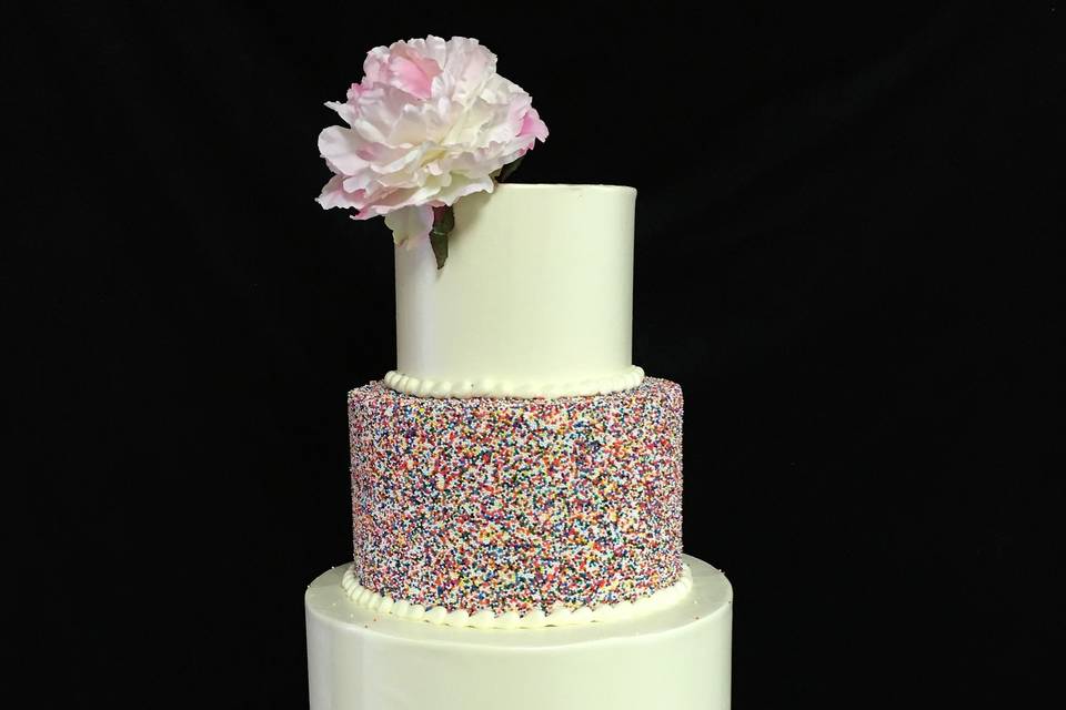 Four layered wedding cake with a flower on top