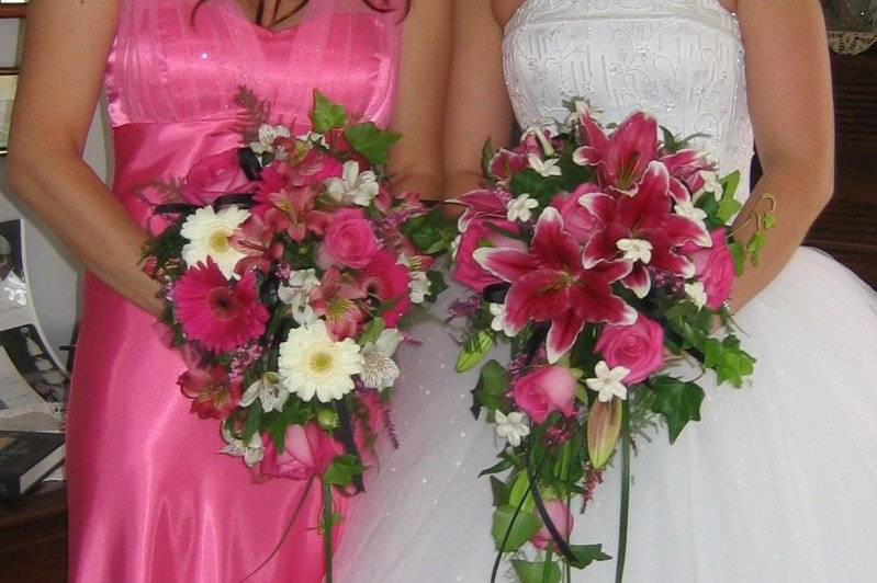 Cascading bouquets with oriental lilies, gerbera daisies, roses, stephanotis, and trails of ivy and lily grasses.