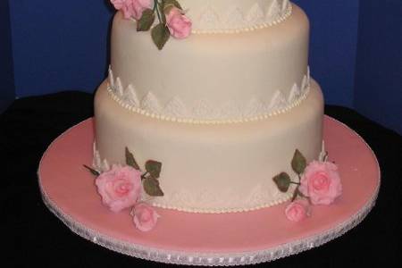 This 4 tiered stacked cake is covered in fondant icing with gumpaste flowers and fondant accents.