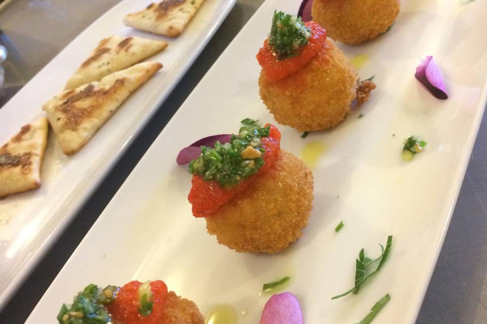 Herb arancini with arugula pesto and rst pepper puree