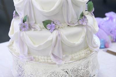 Fondant wedding cake with gumpaste flowers and hand painted.