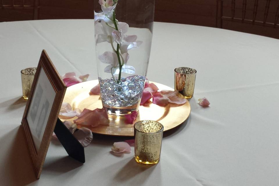 Dendrobium orchids suspended in water with votive candle floating above