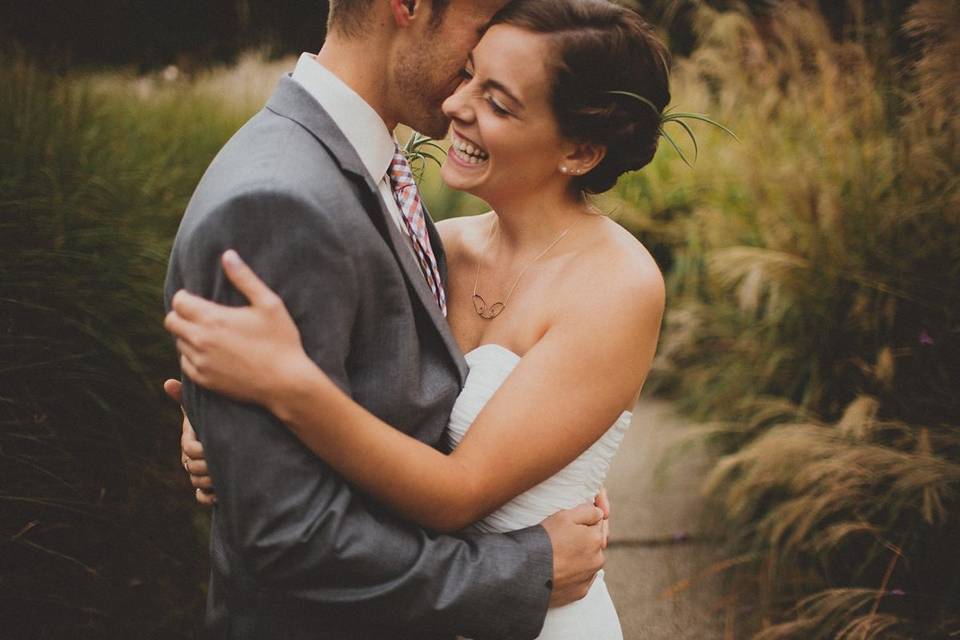 Wedding Couple in front of tall ornamental grasses. Photo credit Ashley Dru Photography.