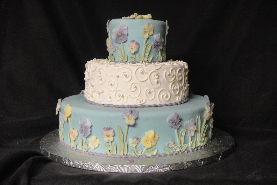 Edible organic flowers and edible pearls adorn this wedding cake.