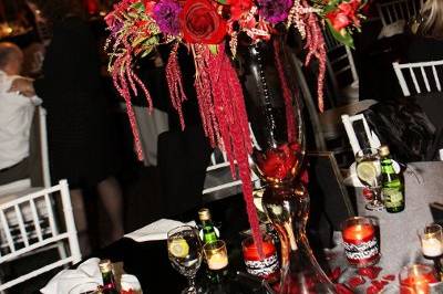 Tall centerpiece featuring roses, lilies, gerber daisies, carnations, dahlias, alstroemeria, hanging amaranthus and curly willow.