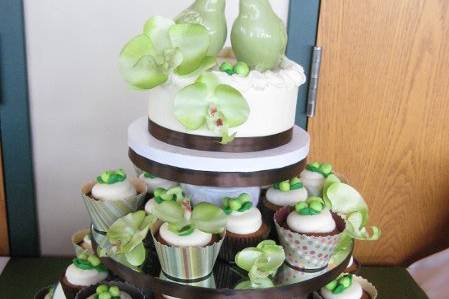 Small cake tier for couple to cut with tiers of cupcakes below. Cupcakes are wrapped in hand-cut cupcake wrappers using scrapbook paper seen in menu cards, escort cards, programs and more.