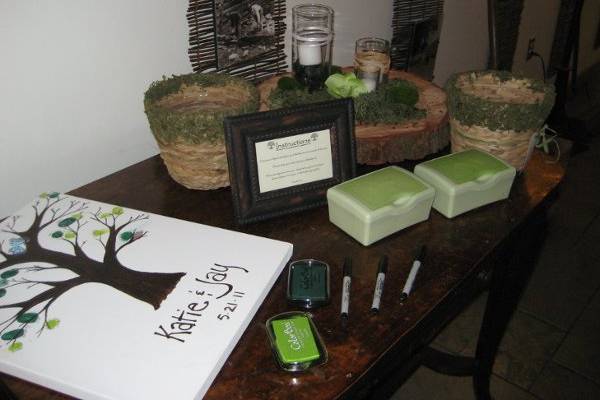 Centerpiece on burlap table runner with river rocks, mosses and succulent plant.