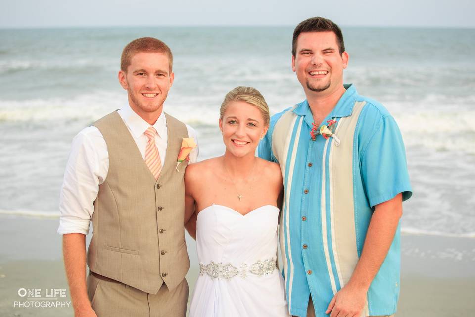 Happy newlyweds with officiant