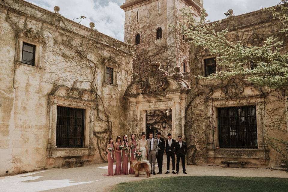 The wedding party under a stone archway