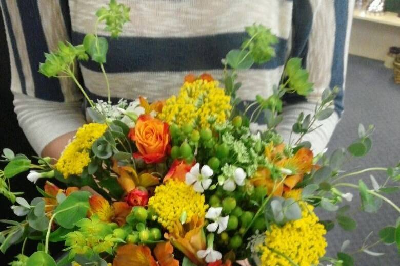 Bridesmaid bouquet of orange alstromeria, orange spray roses, queen annes lace, cottage yarrow, green hypericum, and buplureum