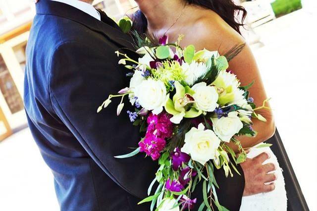 Peacock themed wedding with purple orchids green hydrangea, white roses and purple lisianthus with peacock feathers