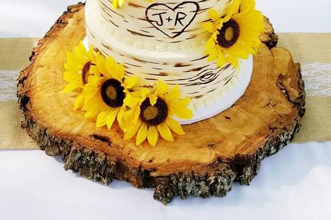 Buttercream rustic wedding cake with silk sunflowers