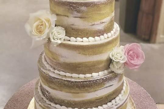 Naked wedding cake with gold brush strokes and fresh flowers