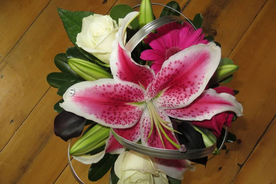 Bouquet with stargazer lilies, escimo roses, plum calla lilies and silver accented lily grass.