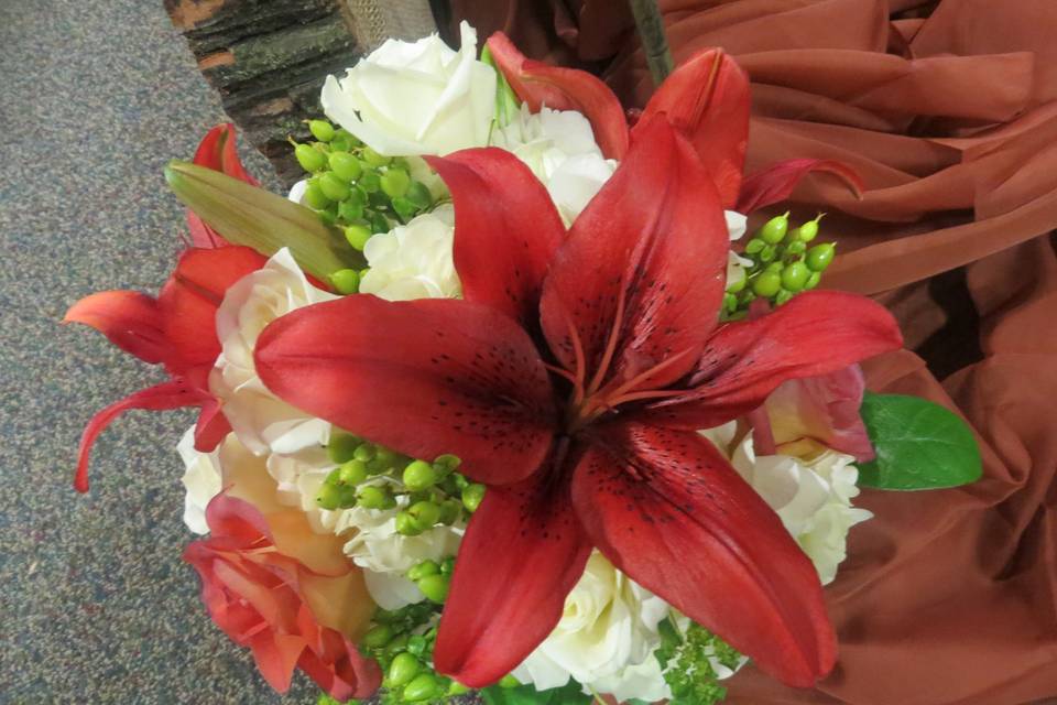 Orange asiatic lilies, green hypericum berries, white hydrangeas, escimo roses and leonitus roses make up this beautiful bouquet.