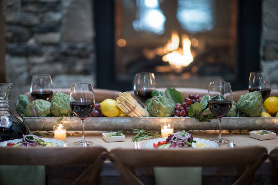 Dining table setup with fruits and vegetable on the center