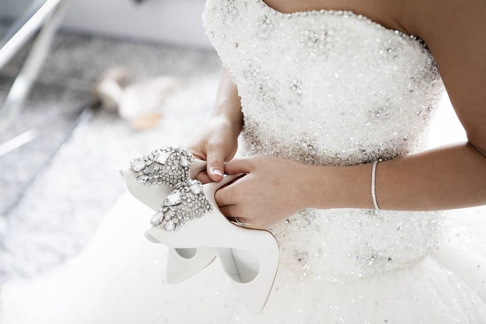 The bride holding her bridal shoes