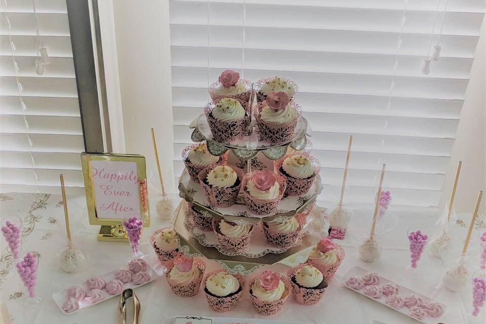 Intimate dessert table with cupcakes, macaroons, merigune cookies and cake pops