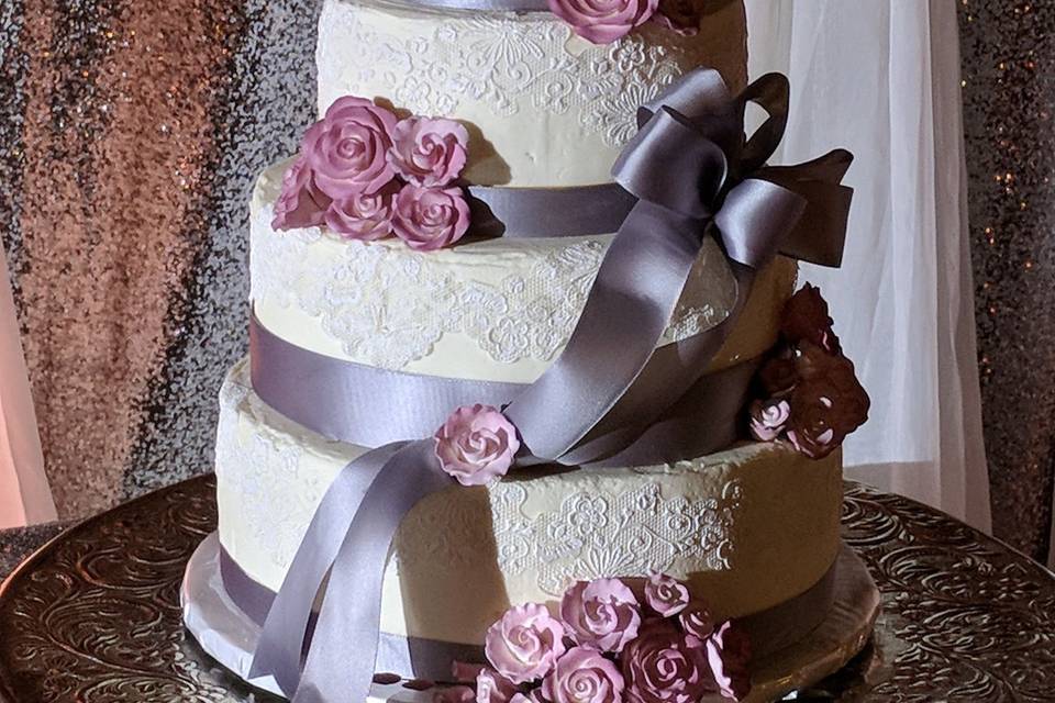 Buttercream frosted cake with edible icing and roses with satin ribbon