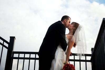 Newlyweds kiss by the rails