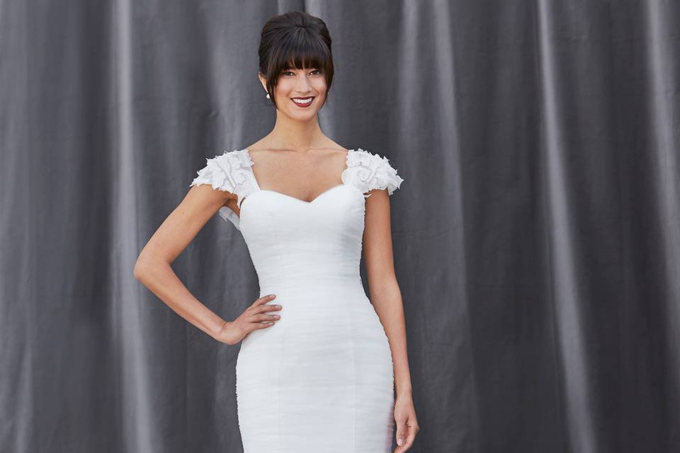 FISHER
A modern fit and flare gown comes with a detachable cap sleeve, sweetheart neckline, and entirely pleated bodice with a full tiered tulle skirt.