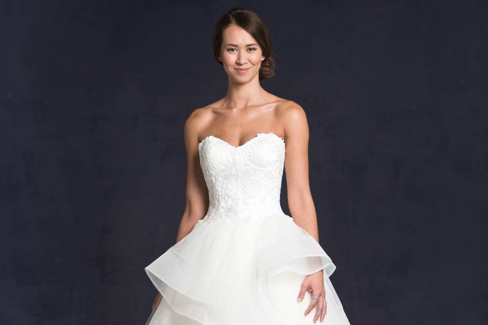 Lis Simon Style:  GWYNETH
Strapless sweetheart neckline, lace appliqué throughout the bodice, ruffled full tulle skirt.  Zipper back.