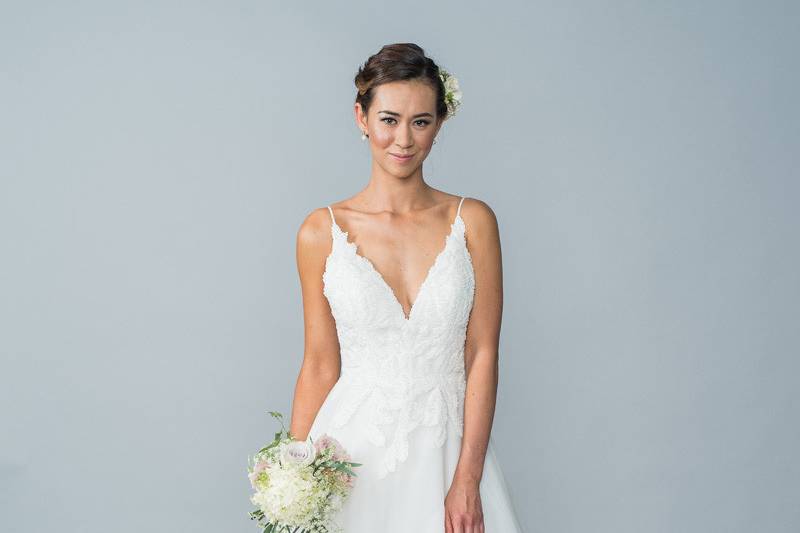 Style Hailey <br> This elegant tulle ball gown features a beaded lace appliqué, fabric buttons and a zipper back. 