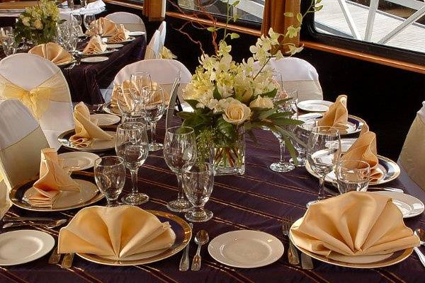 Upgraded linens, chair covers, and floral arrangements in Elite yacht main dining room.